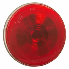 Red incandescent stop light with a round shape and 4 5/16 in overall diameter. Features a pigtail electrical connection and grommet mount for permanent installation. Complies with FMVSS 108 standards. Used on trucks, trailers, and heavy equipment to signal braking.