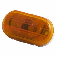 This GROTE clearance marker lamp is an incandescent, oval-shaped light with an amber lens. It features a bracket mount and blunt cut wires for electrical connection. The lamp carries an SAE Lens Code of PC, suitable for vehicle marking applications on trucks, trailers, and heavy equipment to improve visibility and compliance with lighting regulations.
