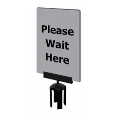 Gray acrylic sign for Tensabarrier posts displaying the message 'Please Wait Here.' Includes mounting adapter for secure attachment. Measures 7 inches wide by 11 inches long. Used to communicate queue instructions and manage pedestrian flow in public areas.