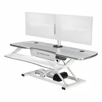 Electronic standing desk converter with a white wood desktop, 48 inches wide and 24 inches deep. Allows users to alternate between sitting and standing positions at a workstation, promoting ergonomic flexibility in office environments