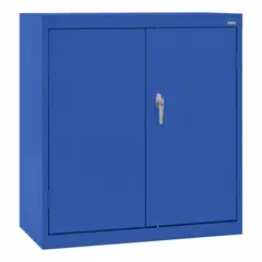 Stationary welded-steel cabinet with blue powder-coated finish. Includes two adjustable shelves and a three-point locking system with swing handle. Mounted on a frame base. Suitable for organized, lockable storage in industrial environments.