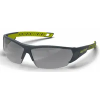 Half-frame safety glasses with padded comfort-fit design. Dark gray photochromic lenses adjust tint to changing light conditions. Anti-fog and scratch-resistant coating. Charcoal/high-visibility yellow frame. Suitable for impact protection in industrial environments such as machining, welding support, and material handling