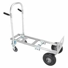 This Dayton hand truck features a dual-handle design with a silver aluminum frame and pneumatic tires. It converts between standard and platform configurations for versatile load handling. The 54-inch handle height accommodates various user heights. Typical applications include moving boxes, appliances, and other bulky items in warehouses, stockrooms, and delivery settings.