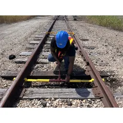 Gauge correction tool for widening or adjusting rail gauge on railroad tracks. Designed for base-of-rail application to correct gauge deviations during track maintenance.
