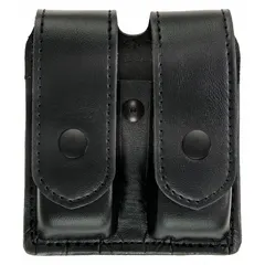 This duty equipment pouch is constructed from black synthetic leather with a plain finish. It measures 5 1/2 inches by 1 3/8 inches and secures contents with a snap closure. Designed for carrying magazines, it is suitable for use by security and tactical personnel.