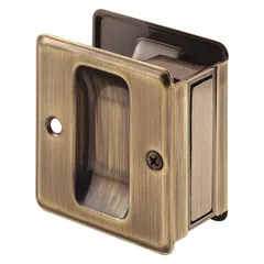 This PRIME-LINE pocket door pull handle is made of brass with an antique brass finish and gold color. It features a tray/lever style and unthreaded mounting holes. Commonly used on cabinet doors, drawers, or sliding panels where a low-profile brass pull is needed.