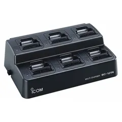 The ICOM BC121NS is a multi-unit adapter that charges up to six radios from the F70, F80, F9011, or F9021 series simultaneously. It operates on a 12 to 16 V DC input and is used in fleet communication environments where multiple radios require concurrent charging.