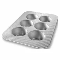 This 6-cup muffin pan is made of aluminized steel with a clear finish, offering even heat distribution for baking muffins, cupcakes, and pecan rolls. The 26 ga gauge construction provides durability for frequent use in commercial or home kitchens. Overall width is 11-1/8 inches
