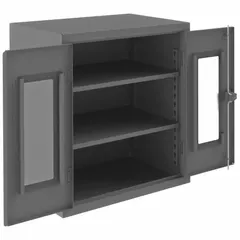This assembled frame cabinet in gray measures 36 x 24 x 42 inches and includes two adjustable shelves with a swing door. Designed for organized storage of tools, parts, and supplies in workshops, warehouses, and maintenance facilities, it provides secure, visible access to stored items.