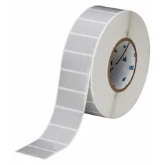 Precut label roll for industrial identification. Polyester material in gray, measuring 2 13/64 in x 1 in. Contains 3000 labels per roll. Compatible with THT printer series. Used for asset tracking, cable marking, and component labeling.